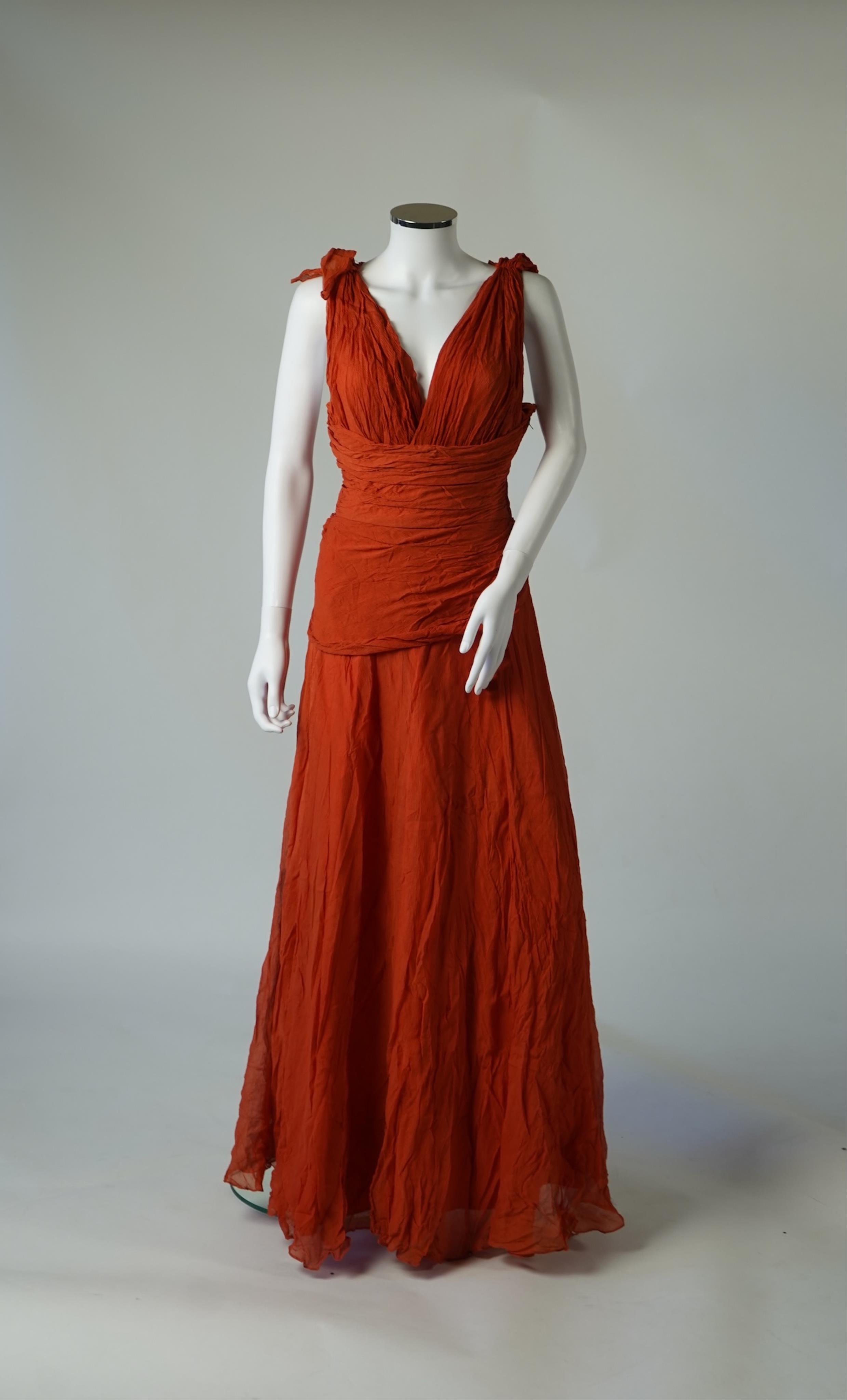 A 1940’s orange chiffon evening dress, with an orange silk taffeta lining, a pleated bodice and front apron panel tied at the back., 156 cm long. Condition - there are a few small holes in the chiffon at the back of the